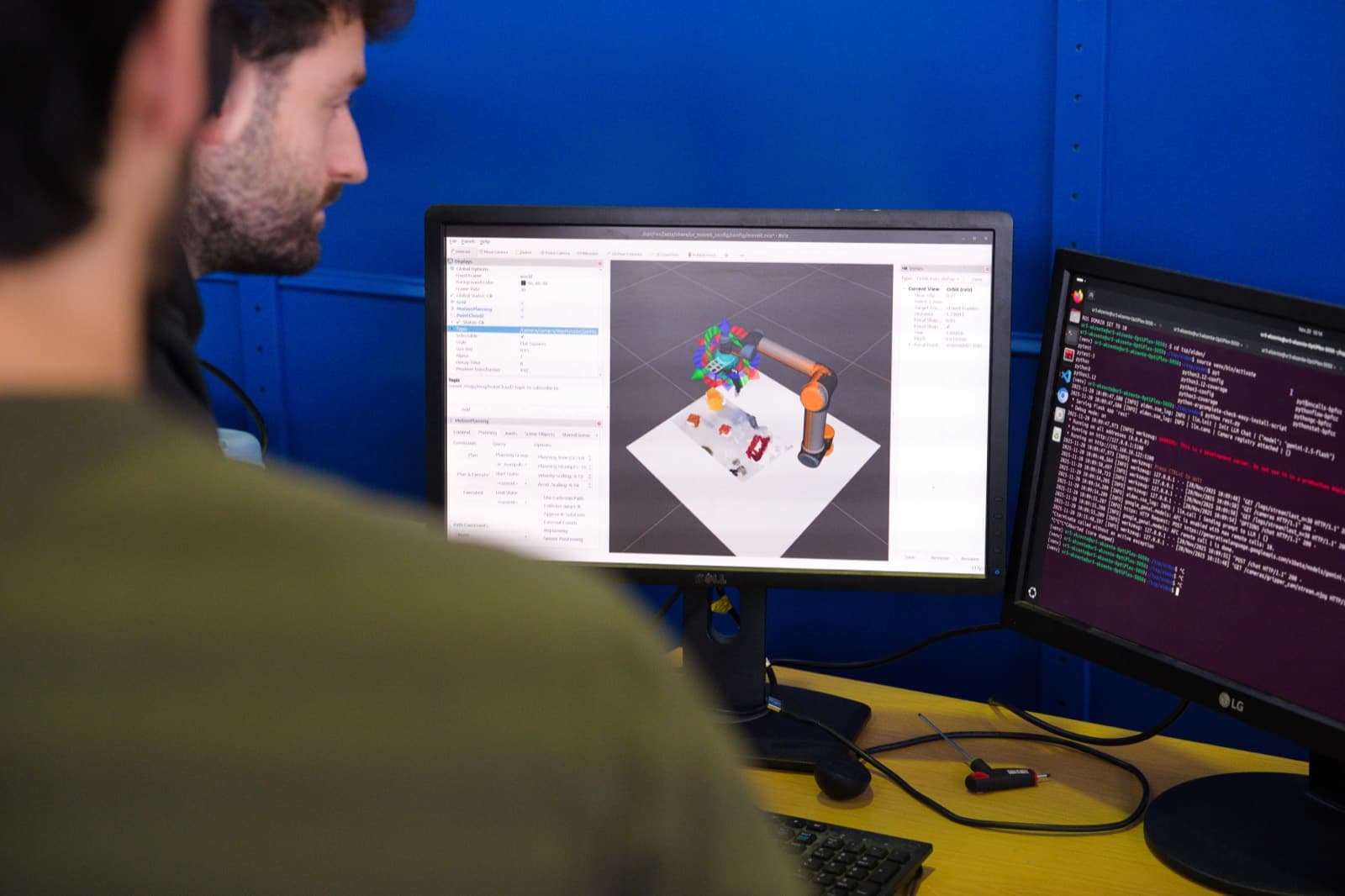 Ingenieur prüft eine Roboter-Bahnplanung in der Simulation am Monitor