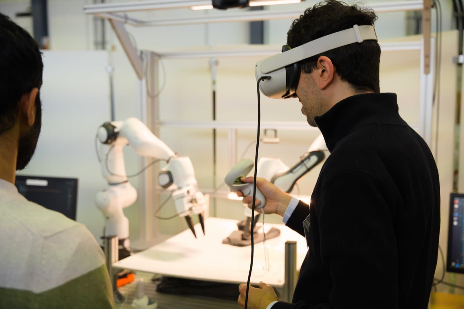 Ingenieur mit VR-Headset führt einen Roboterarm über einen Handcontroller